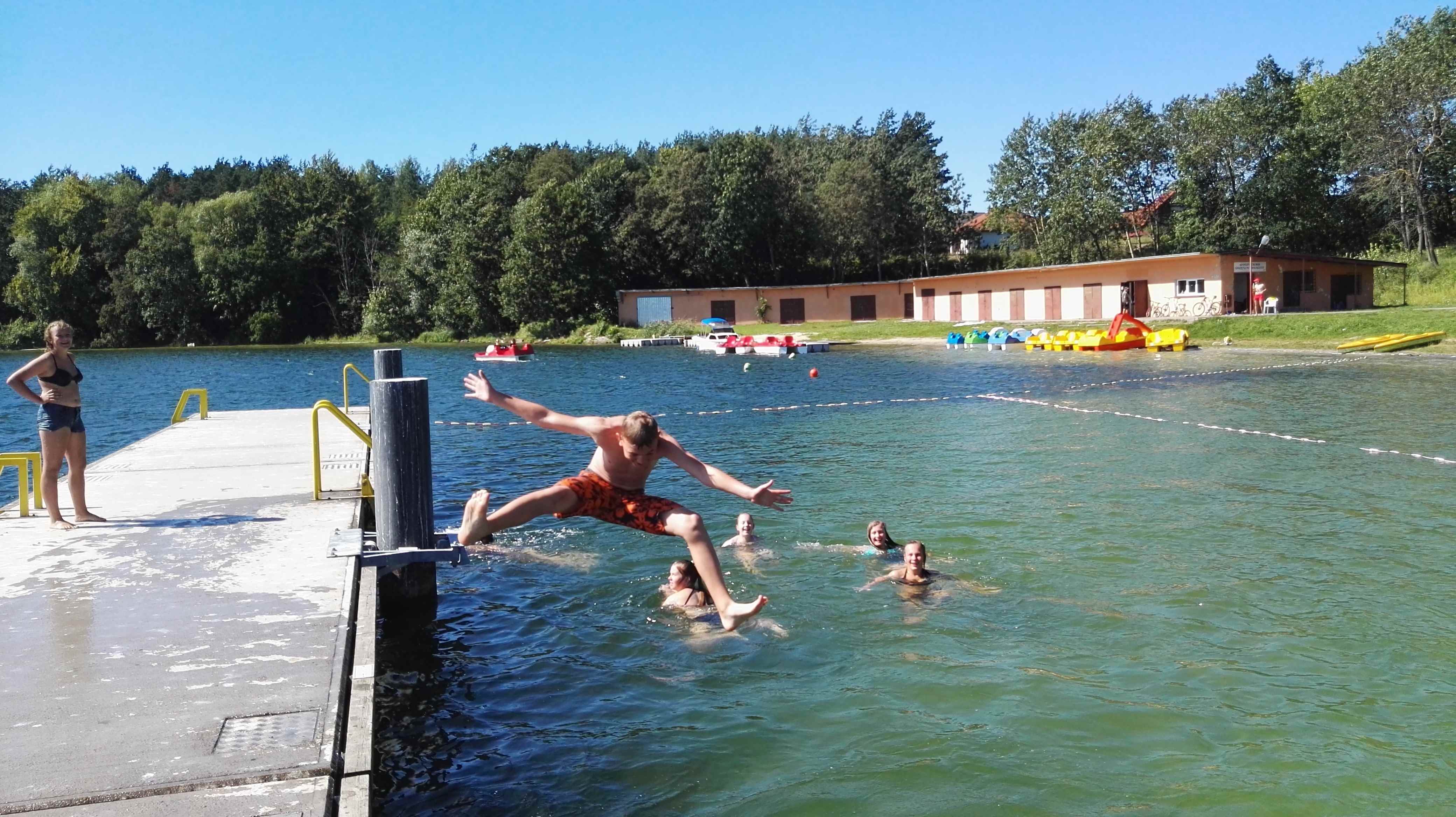 uczestnicy obozu sportowego wypoczywają nad jeziorem